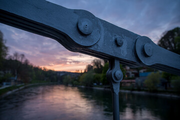 Glowing sunset over the Aare river with the bridge chain in front