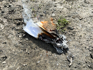 burning paper lies on the ground