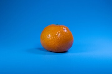 Closeup of a fresh orange isolated on a blue background
