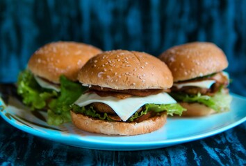 Closeup view of three delicious homemade burgers on a plate