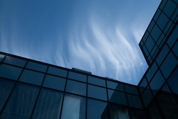 Low angle of a modern glass building against the blue sky