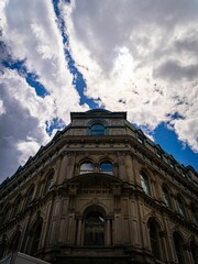 Vertical low angle of the Montreal Telegraph Company building facade against the cloudy blue sky