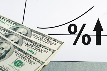 Interest rate increase. Chart with rising interest rates and dollar banknotes.