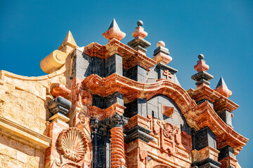 Detail of the red and black marble facade of the Basilica de la Vera Cruz in Caravaca, Murcia, Spain with columns and profuse decoration