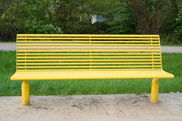 Gelbe Sitzbank aus Metall im Grünen
