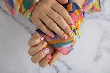 Pastel softness colorful manicured nails. Woman showing her new summer manicure in colors of pastel palette. Simplicity decor fresh spring vibes earth-colored neutral tones