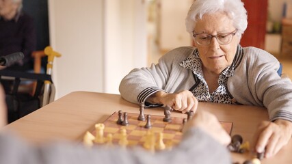 Senior friends playing chess in a nursing home