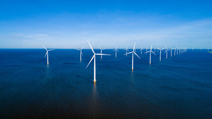 A group of wind turbines stand tall in the ocean, harnessing the power of the wind to generate...