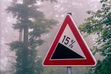 Verkehrsschild Gefälle 15% im Nebel-Wald