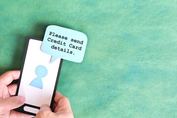 Send credit card bank details text message smishing scam concept. Hand holding mobile phone with message from unknown sender.