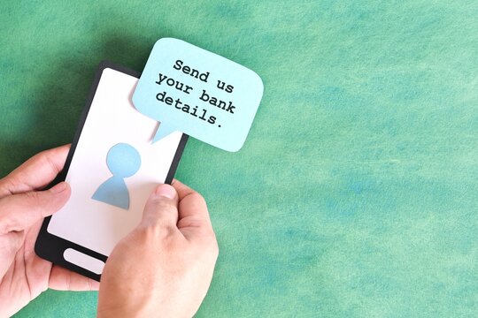 Send credit card bank details text message smishing scam concept. Hand holding mobile phone with message from unknown sender.