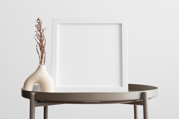 White square frame mockup with a dry flower decoration on the beige table.