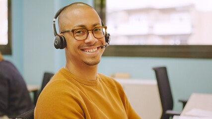 Smiling man using headset while working in a coworking