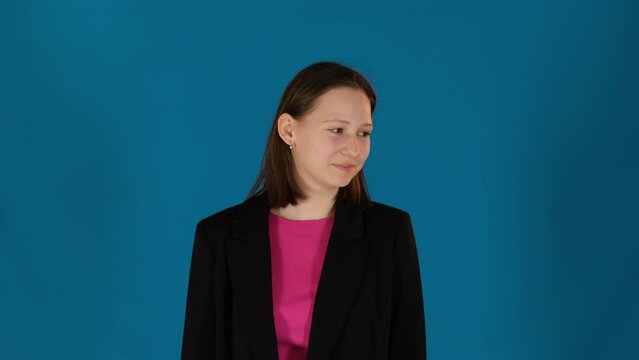 Lady averts eyes with shy demeanor adding endearing charm on blue background. Woman bashful expression adds touch of innocence