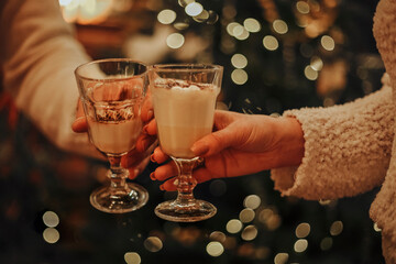 Couple in love drinking homemade eggnog by the Christmas tree