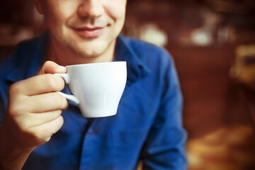 Man drinking white tea cup in cafe
