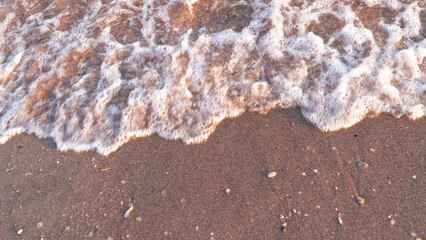 Sandy beach background with sea waves.