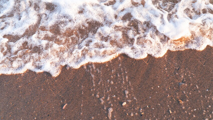 Fototapeta na wymiar Sandy beach background with sea waves.