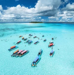 Foto auf Acrylglas Aerial view of colorful boats in transparent water on sunny day. Mnemba island, Zanzibar. Top view of sandbank in low tide, blue sea, sand, swimming people, yachts, sky with clouds in summer. Ocean © den-belitsky