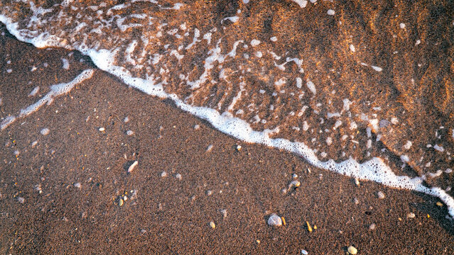 Sandy beach background with sea waves.