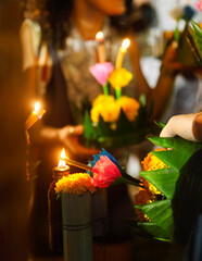 Woman holding boat with candles and flowers are given for Thailands traditional Loy Krathong Festival - obrazy, fototapety, plakaty