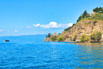 Lake Ohrid, North Macedonia, April 13 2024. Mountain range and peninsula in distance. Ohrid Lake, Macedonia, Europe. The clear mesmerizing waters of lake Ohrid with a beautiful view.  - obrazy, fototapety, plakaty
