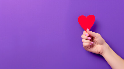 Hand holding a red heart on a purple background.