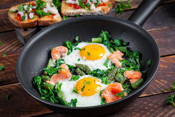 Keto breakfast. Fried eggs  with asparagus, spinach and salmon. - 784438822