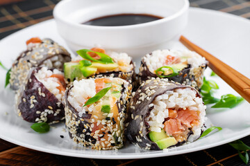 Spring roll with nori, sushi rice, salmon, cucumber and avocado, sriracha and sesame mayonnaise. - 784439065