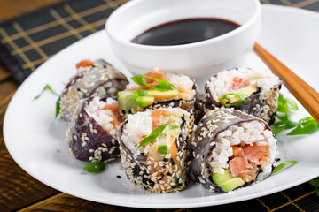 Spring roll with nori, sushi rice, salmon, cucumber and avocado, sriracha and sesame mayonnaise. - 784439082