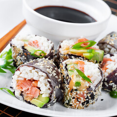 Spring roll with nori, sushi rice, salmon, cucumber and avocado, sriracha and sesame mayonnaise. - 784439086