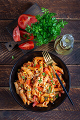 Classic italian pasta penne arrabbiata with vegetables on wooden table. Penne pasta with sauce arrabbiata. Top view, overhead - 784439271