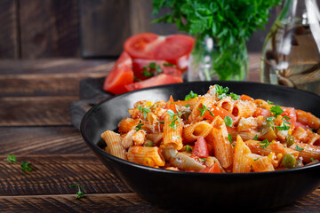 Classic italian pasta penne arrabbiata with vegetables on wooden table. Penne pasta with sauce arrabbiata. Top view, overhead - 784439446