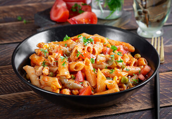 Classic italian pasta penne arrabbiata with vegetables on wooden table. Penne pasta with sauce arrabbiata. Top view, overhead - 784439484