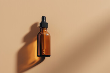 Amber glass dropper bottle on beige background, minimalistic skincare packaging.