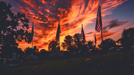 A sunset ceremony at a veteran's cemetery, with American flags silhouetted against the fiery sky. 
