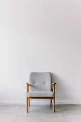 Minimalist modern grey armchair against a white wall, Scandinavian interior design.