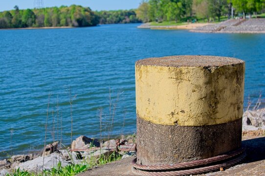 Concrete mooring post with steel cable on lake shore