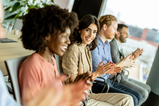 Energetic applause by a diverse group at a casual indoor event
