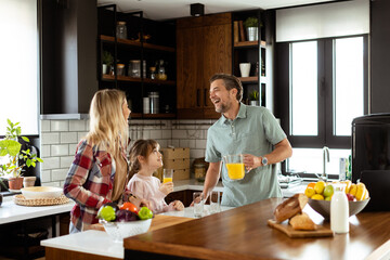 Family chatting and preparing food around a bustling kitchen counter filled with fresh ingredients and cooking utensils