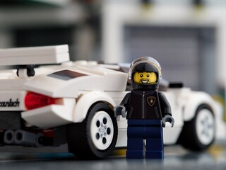 Fototapeta premium Tambov, Russian Federation - February 20, 2024 Lego Lamborghini Countach driver minifigure standing near back of his car. LEGO Speed Champions.