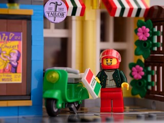 Fototapeta premium Tambov, Russian Federation - January 21, 2024 Lego pizza delivery man minifigure with his moped on Lego street