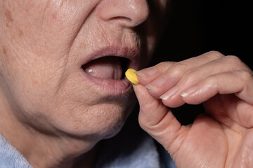 Old Woman Puts the Pill in Her Mouth