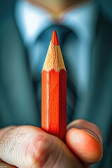 Close up of a person holding a red pencil, perfect for educational or artistic concepts