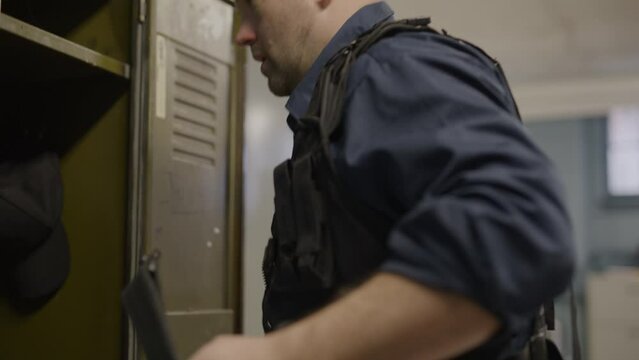 Police officer suiting up in tactical gear