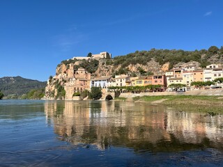 Fototapeta na wymiar Spanish Castle of Miravet at the river Ebro with surrounding village on sunny day with bright Blue sky