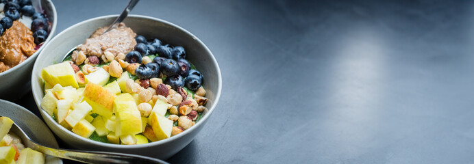 Green smoothie bowl with fresh apple, blueberries, hazelnuts and almond butter. Healthy balanced...