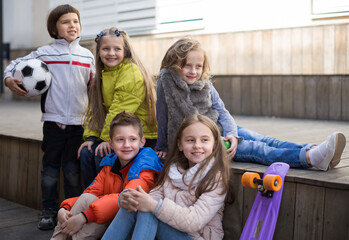 Group of children sitting on wooden scaffolding schoolyard