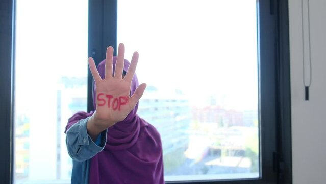 A Muslim woman with belo with the palm of her hand wrote the word stop stop. Equal rights, non-discrimination, no Islamophobia, no racism and discrimination. Effective equality of rights and equity be