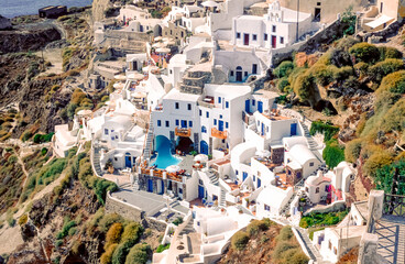 Häuser, Bungalows in Thera bzw. Oia, zwei kleine Dörfer auf dem Kraterrand der griechischen Insel Santurin im ägäischen Meer im Mittagslicht der Sonne - 784490602